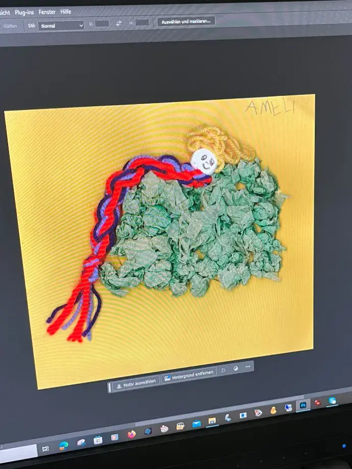 Wir verbessern die Scans. Gebasteltes Kinderkunstwerk zeigt eine Prinzessin mit buntem Zopf und grünes Kleid auf gelben Hintergrund, dieses Bild ist als Scan auf Computerbildschirm zu sehen.